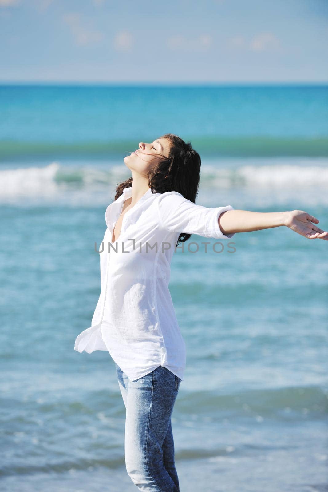 happy young woman on beach by dotshock