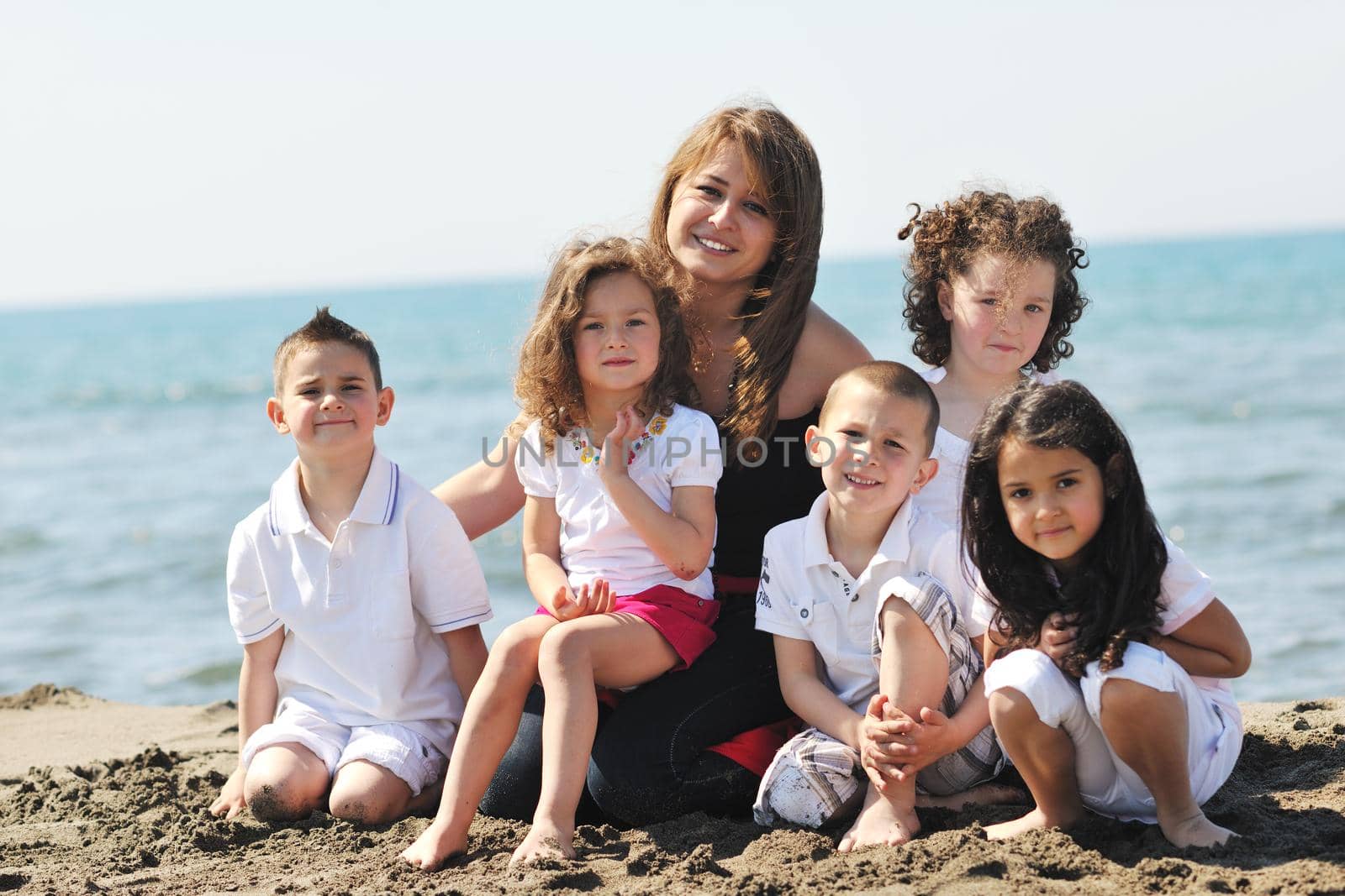 group portrait of childrens with teacher on beach by dotshock