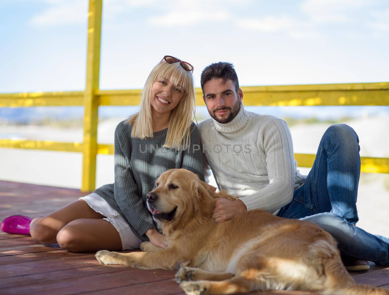 Couple with dog enjoying time on beach by dotshock