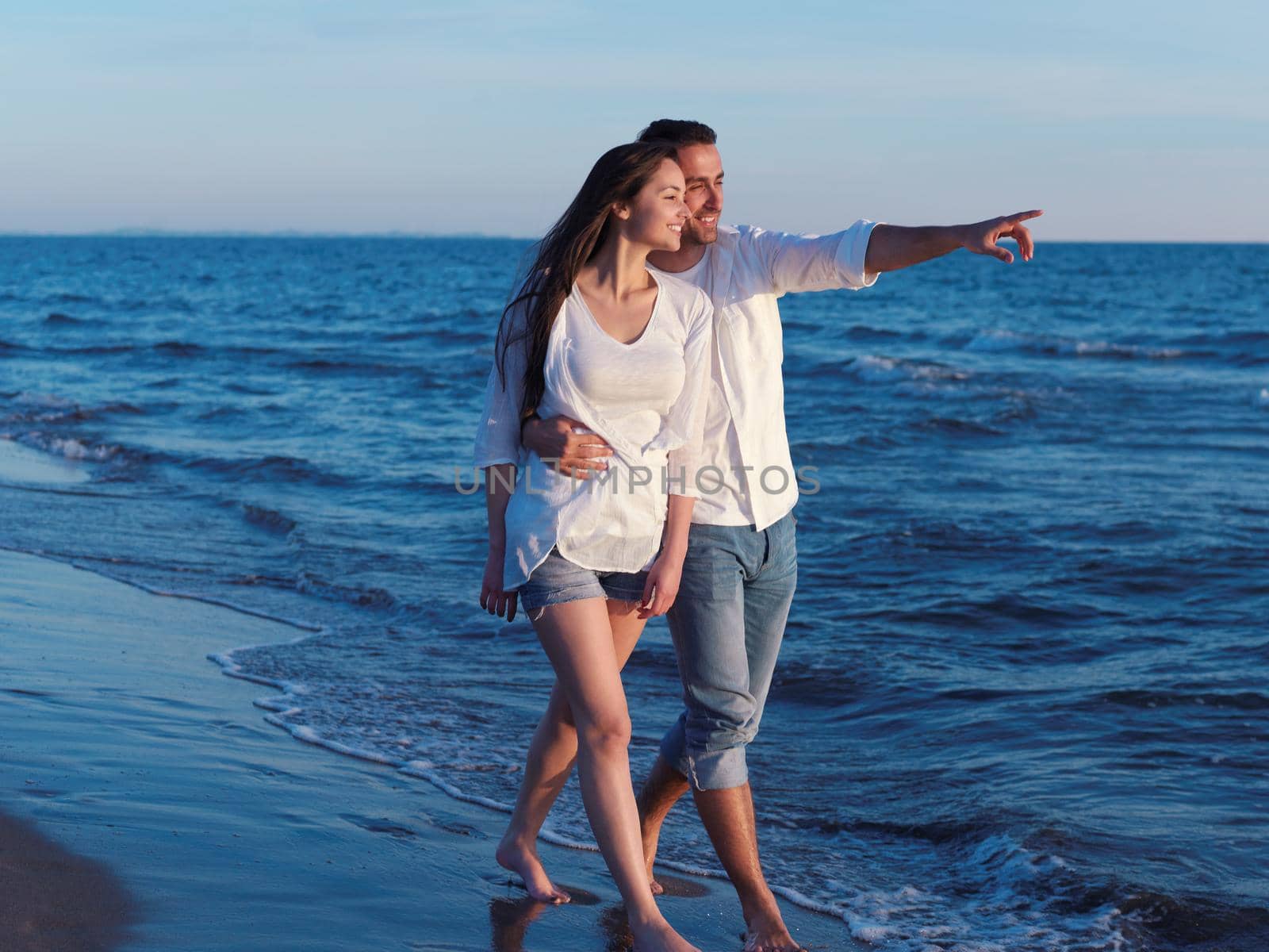 happy young romantic couple in love have fun on beautiful beach at beautiful summer day