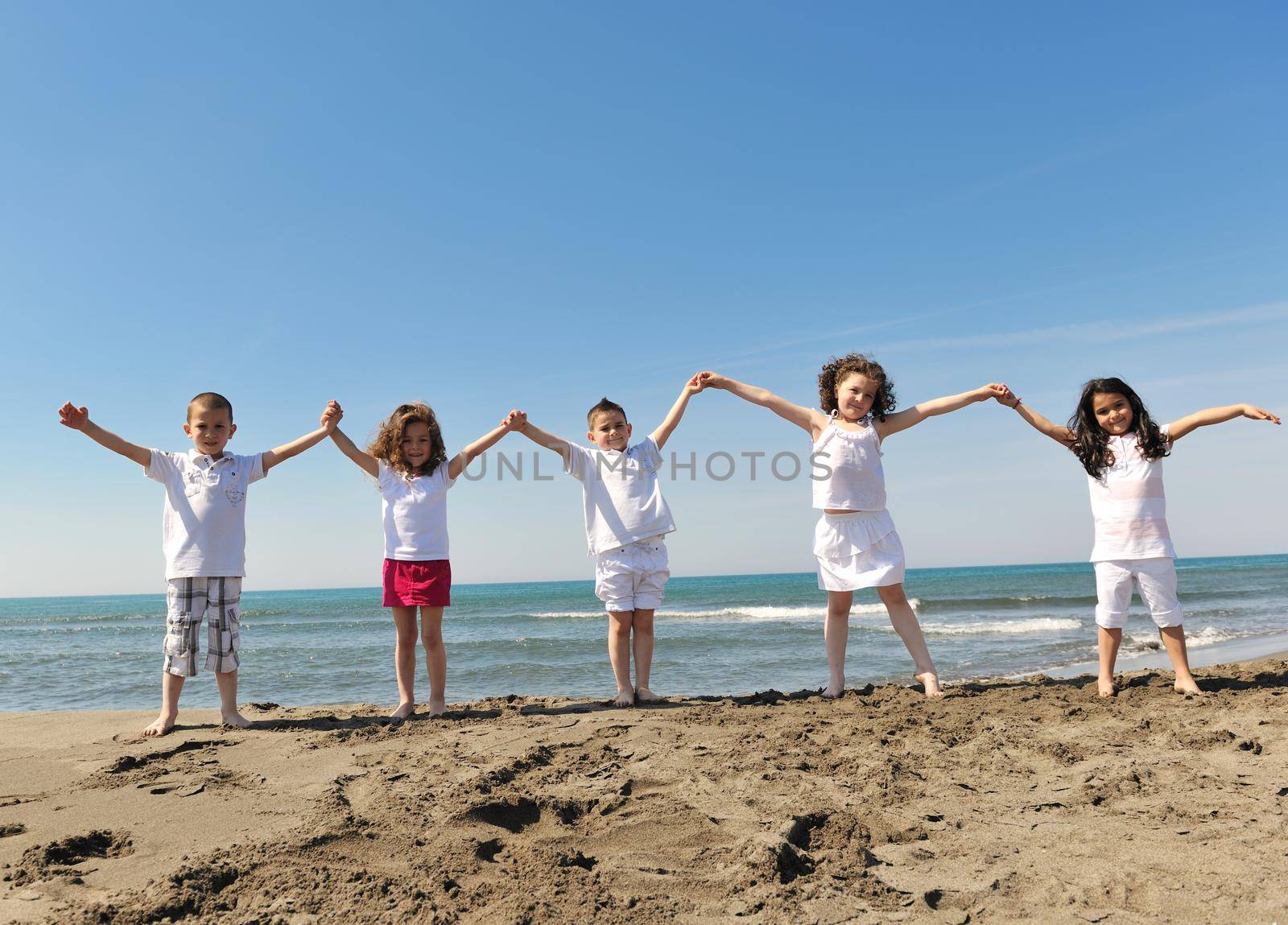 happy child group playing  on beach by dotshock