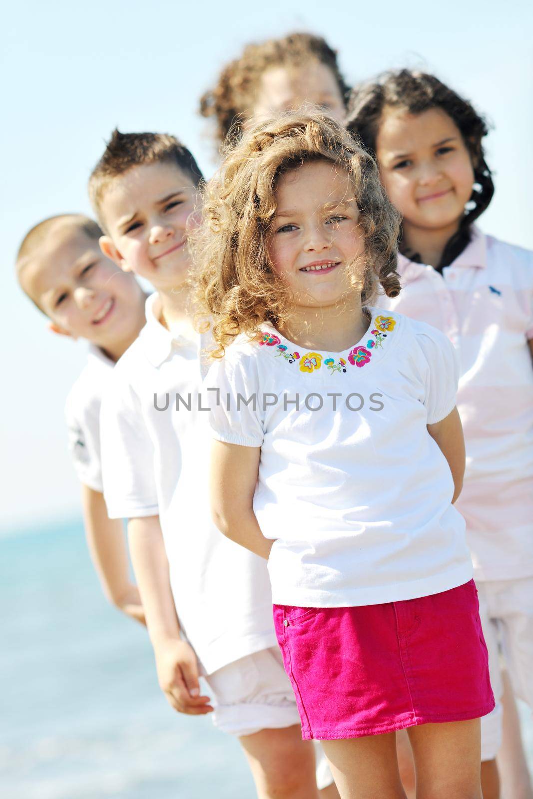 happy child group playing  on beach by dotshock