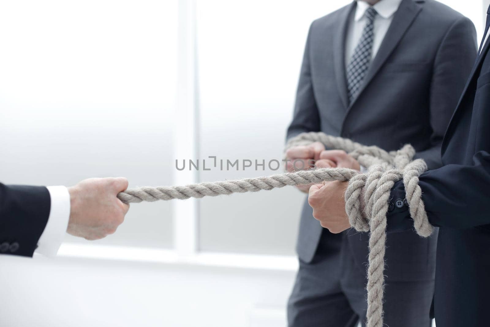 close up.businessman drags his business team by the rope by asdf