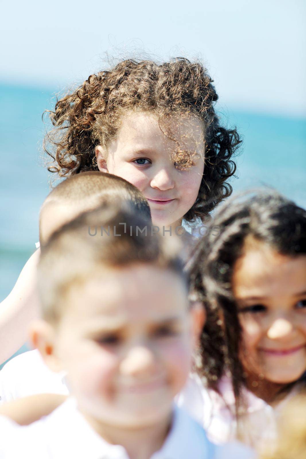 group of happy child on beach who have fun and play games