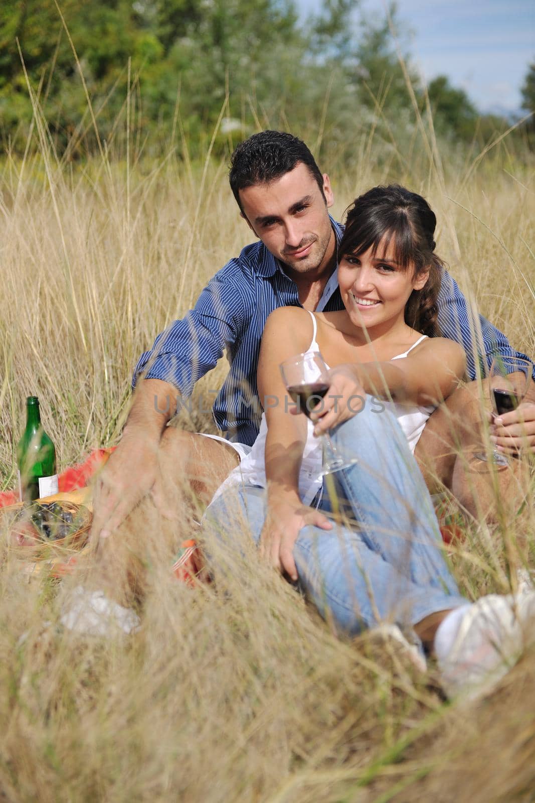 happy young couple enjoying  picnic on the countryside in the field  and have good time