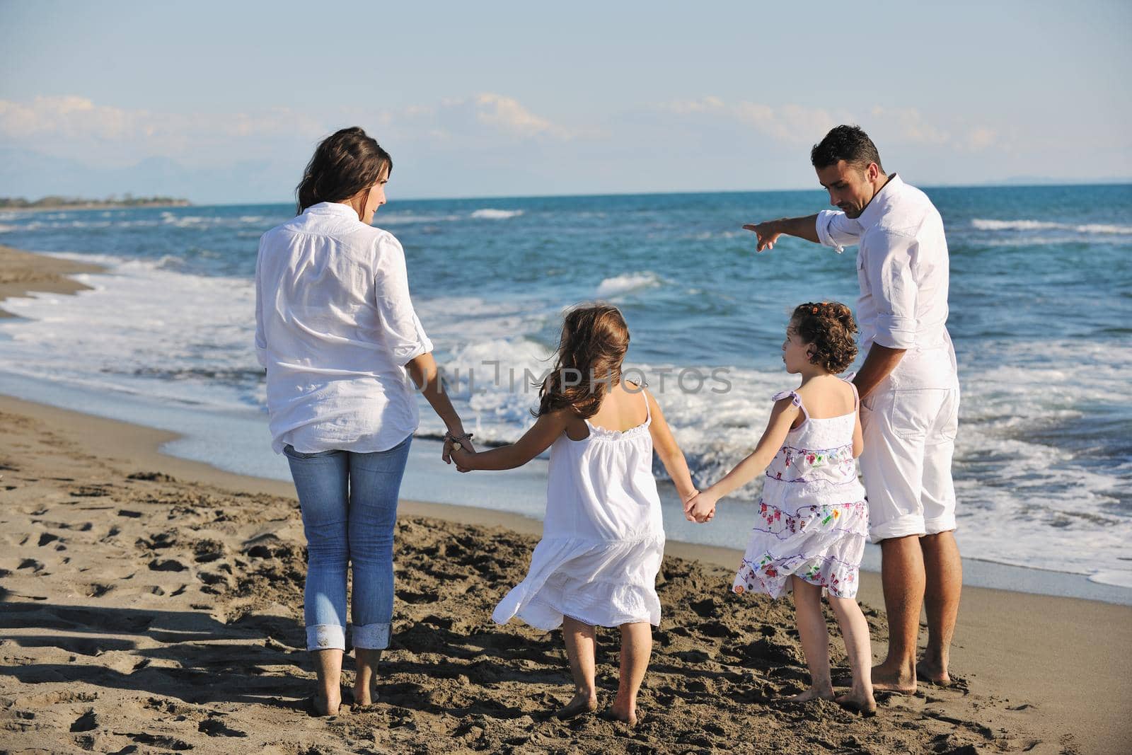 happy young family in white clothing have fun at vacations on beautiful beach 