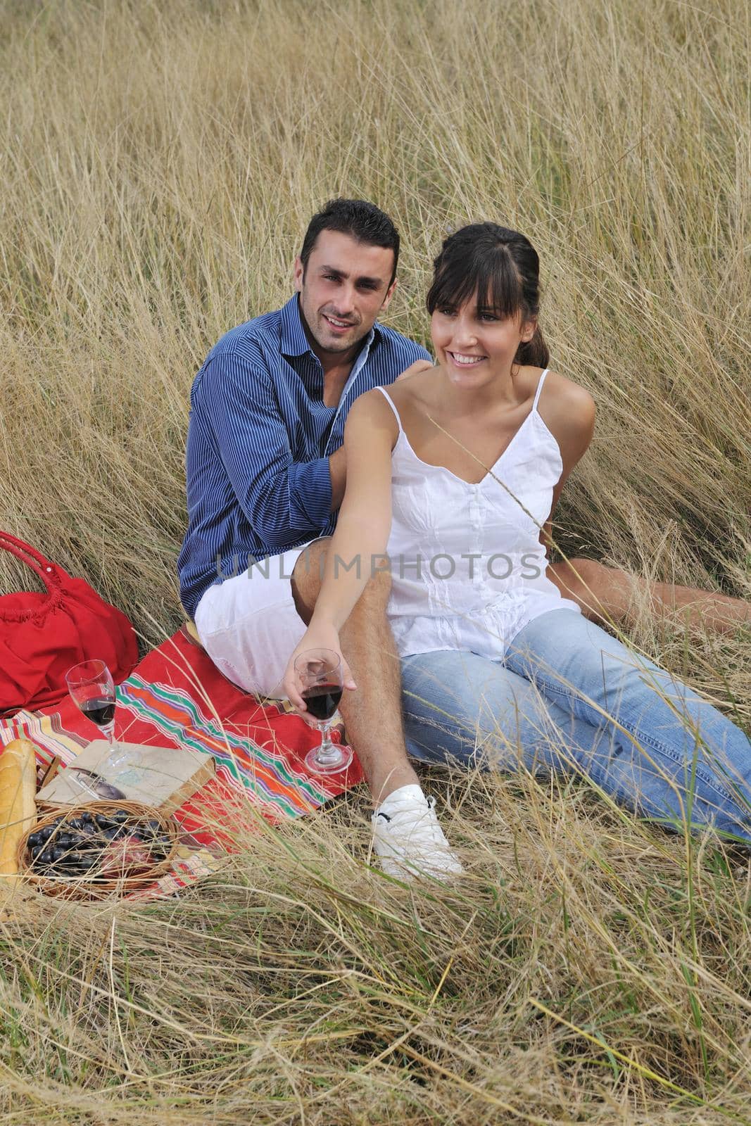 happy young couple enjoying  picnic on the countryside in the field  and have good time