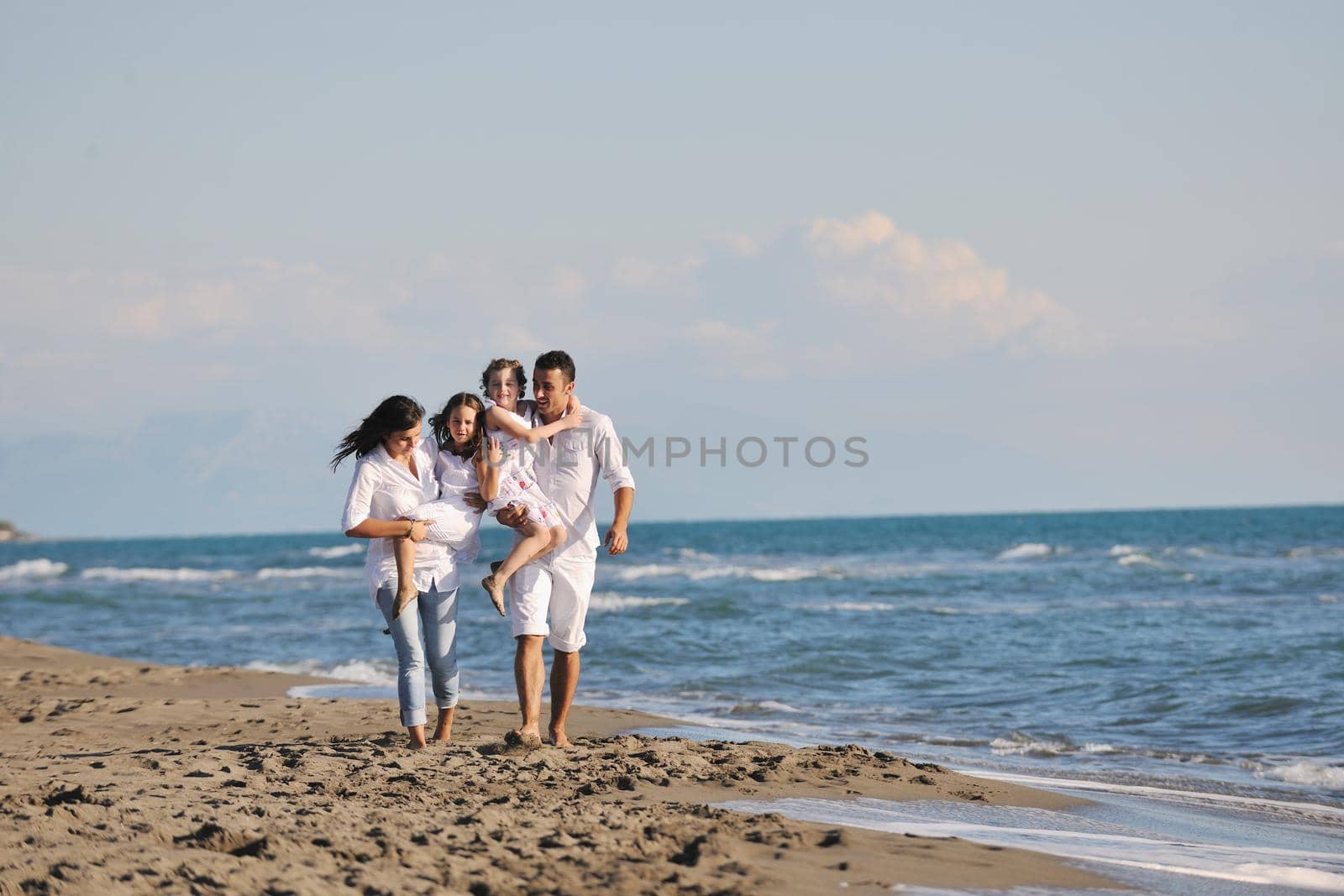 happy young family in white clothing have fun at vacations on beautiful beach 