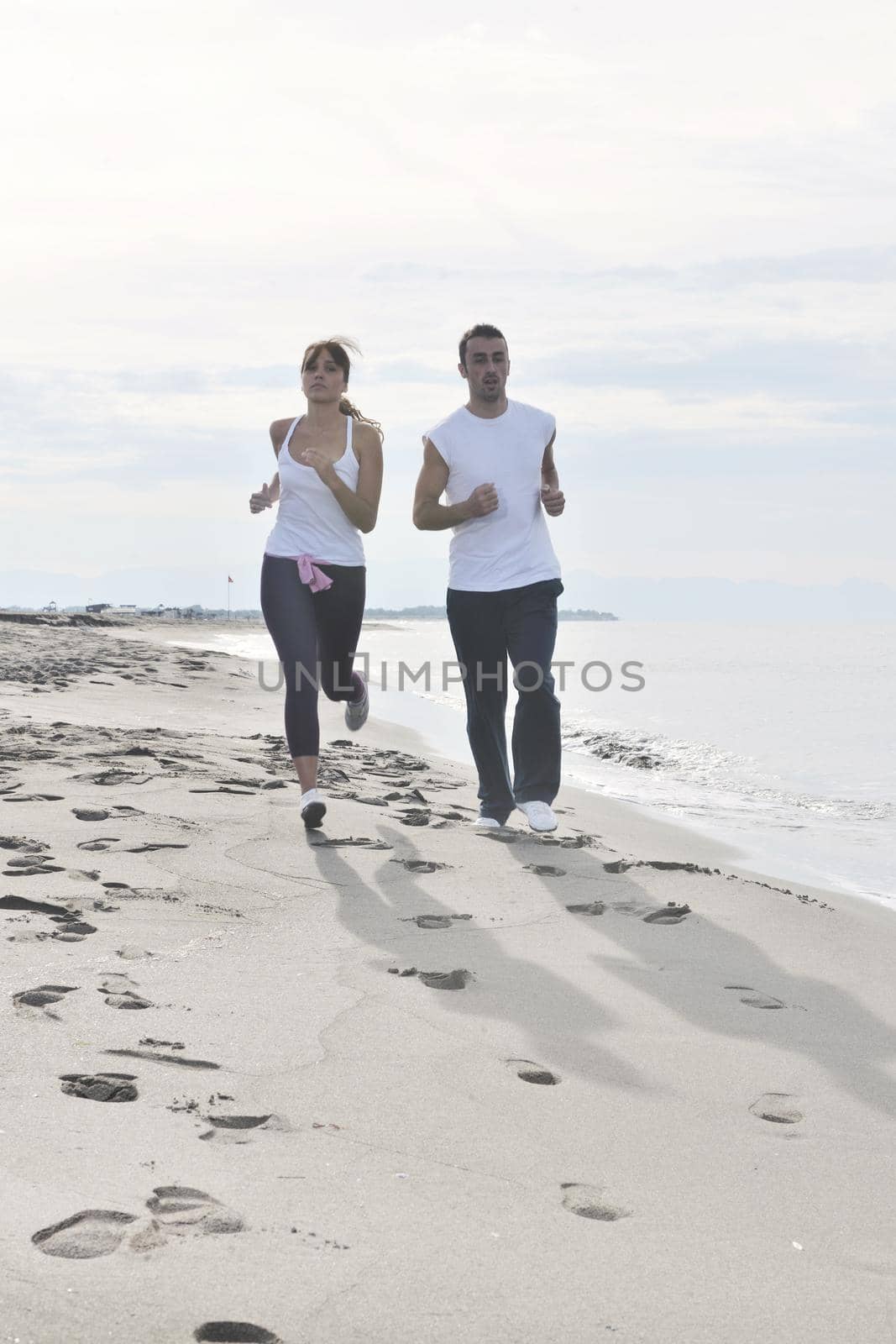 couple jogging on the beach by dotshock