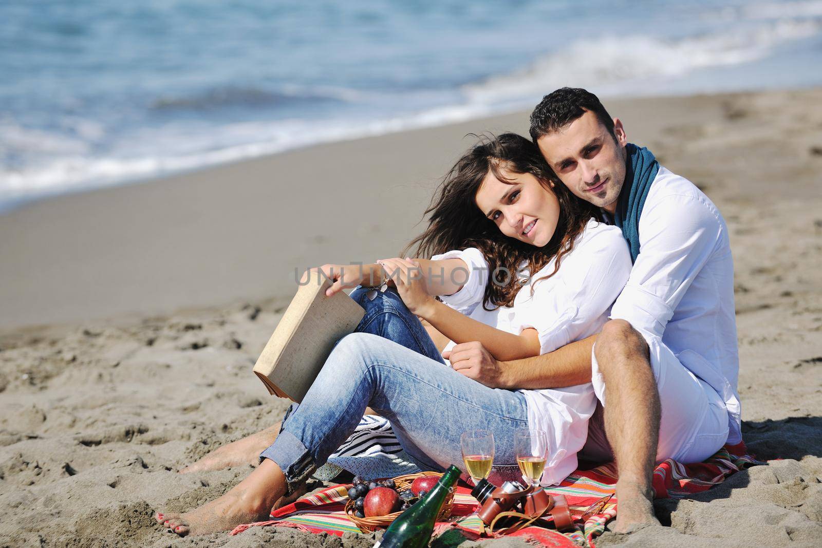 happy young couple enjoying  picnic on the beach and have good time on summer vacations