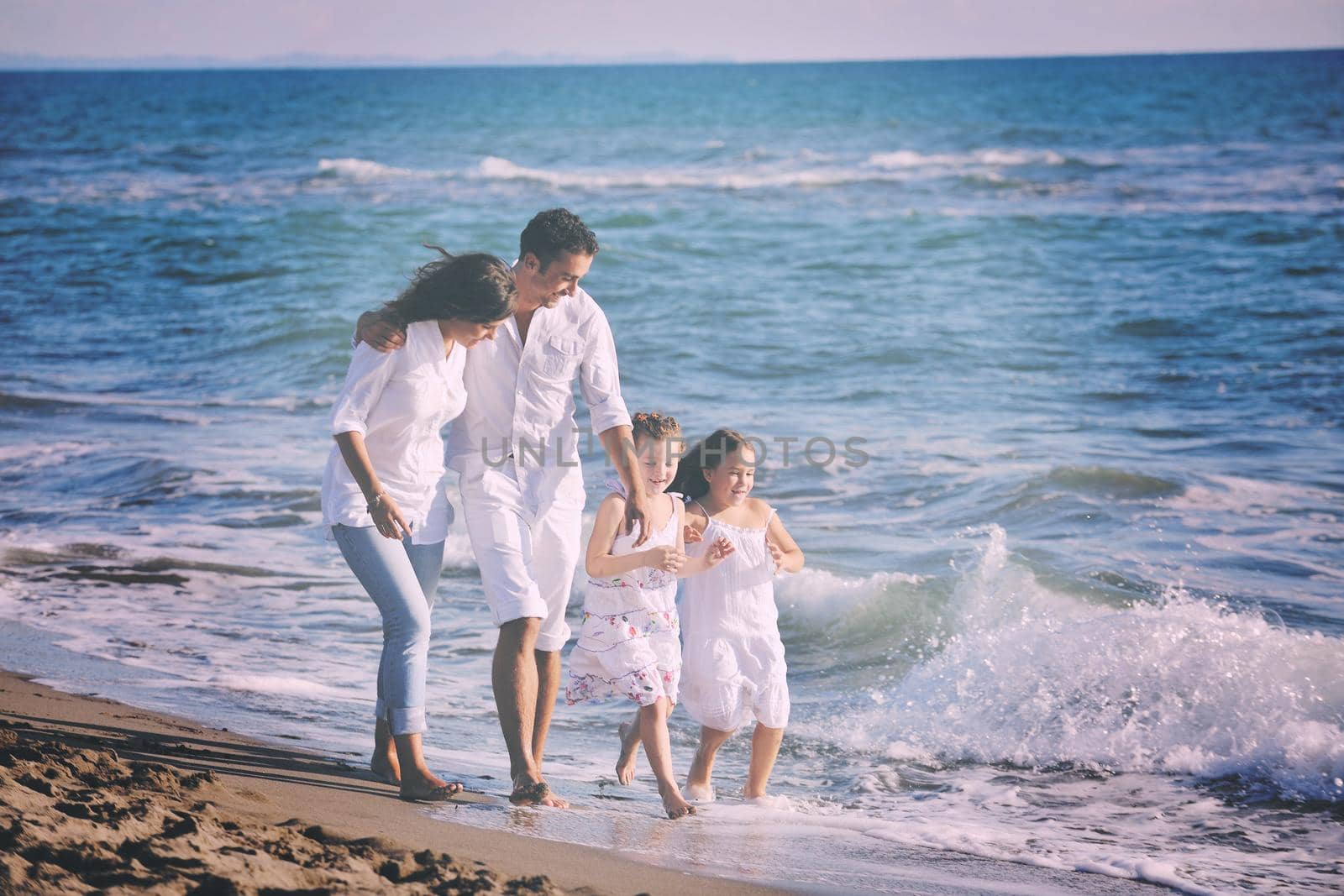 happy young family in white clothing have fun at vacations on beautiful beach 