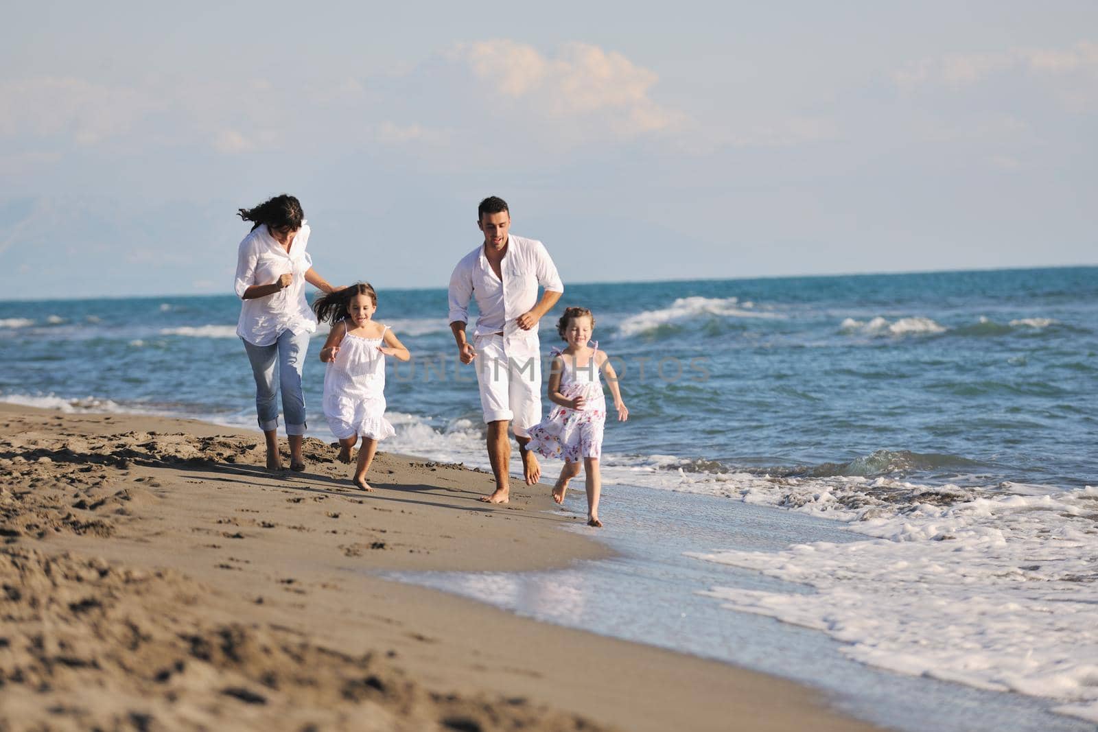 happy young family in white clothing have fun at vacations on beautiful beach 