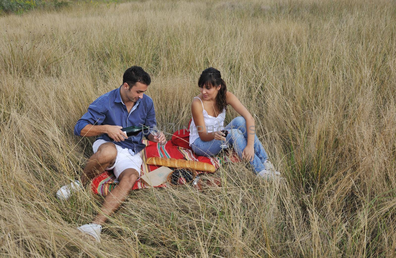 happy young couple enjoying  picnic on the countryside in the field  and have good time