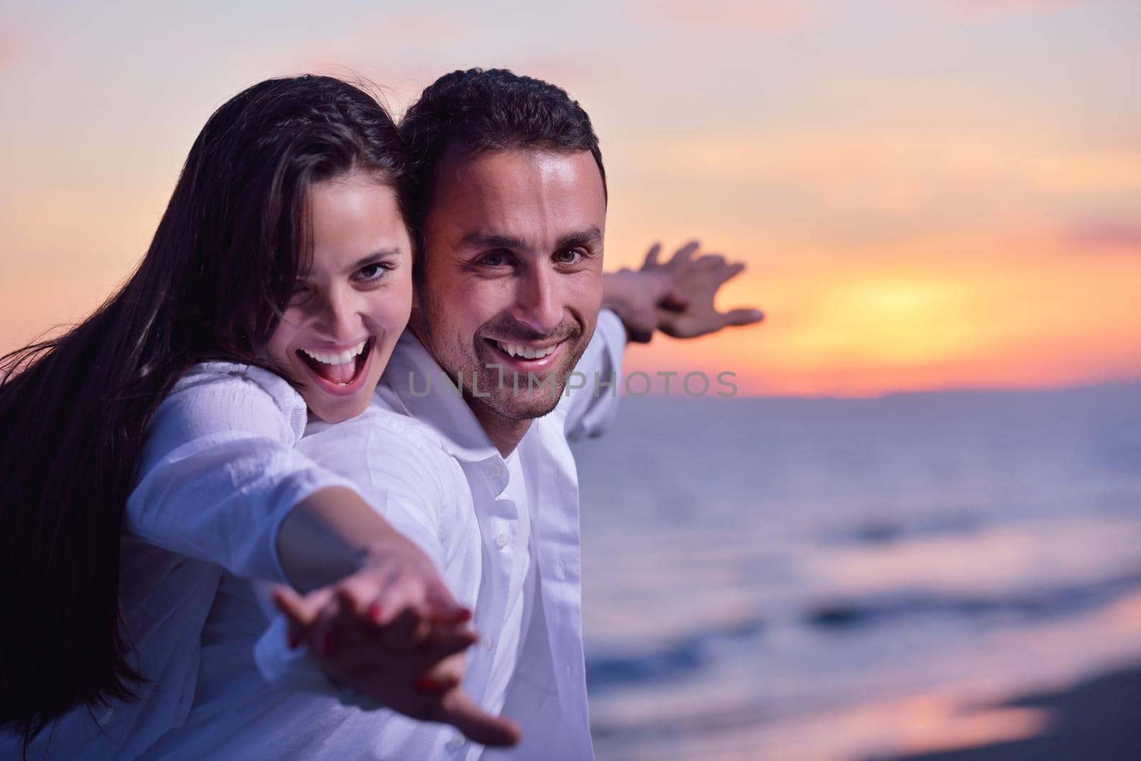 happy young romantic couple in love have fun on beautiful beach at beautiful summer day