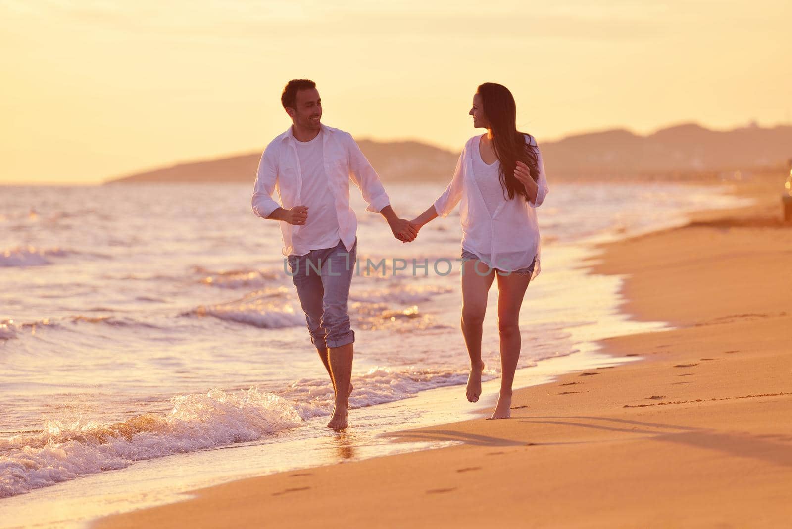 happy young romantic couple in love have fun on beautiful beach at beautiful summer day