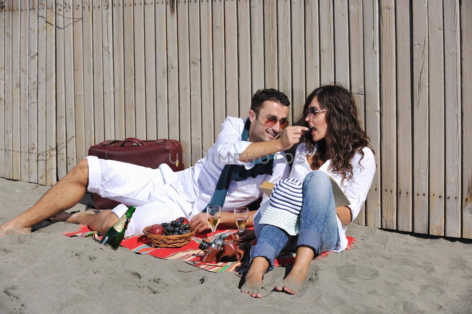 happy young couple enjoying  picnic on the beach and have good time on summer vacations