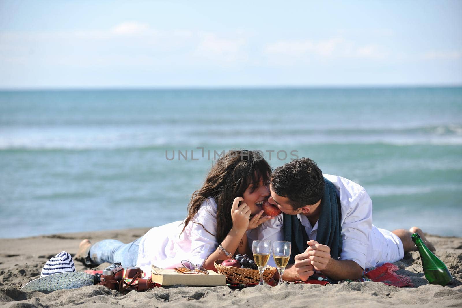 happy young couple enjoying  picnic on the beach and have good time on summer vacations