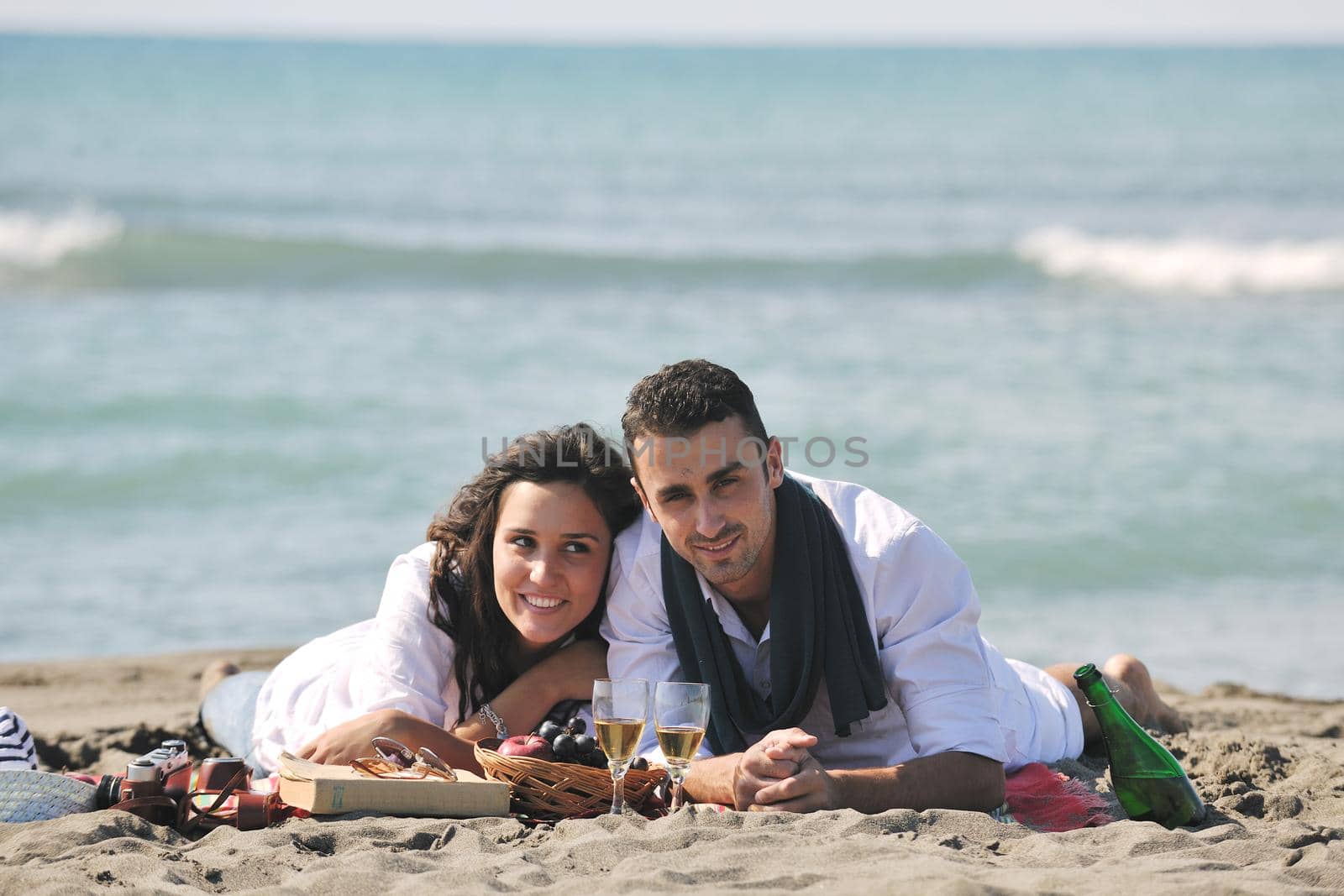 happy young couple enjoying  picnic on the beach and have good time on summer vacations