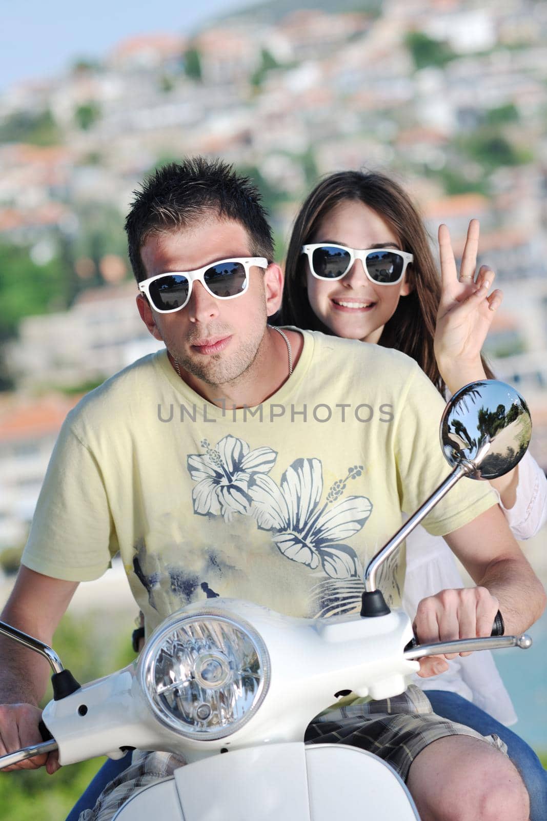 Portrait of happy young love couple on scooter enjoying summer time by dotshock