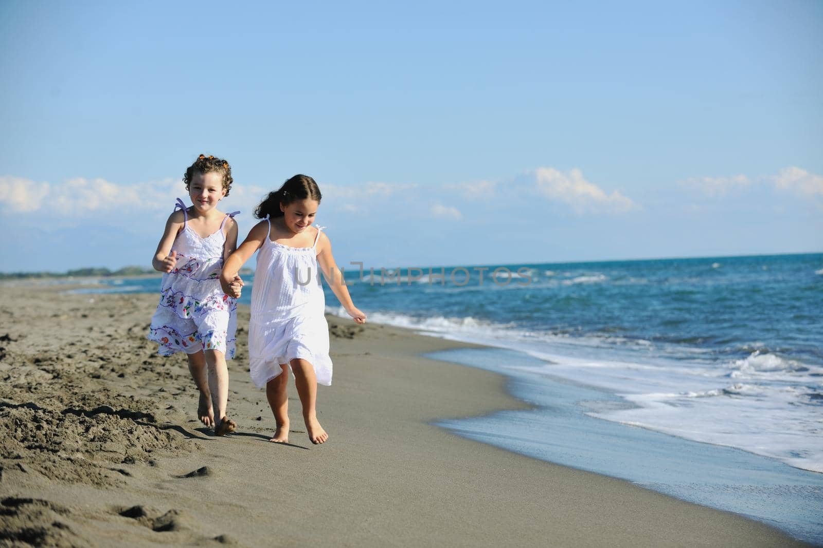 happy two little girls have fun and joy time at beautiful beach while running from joy 