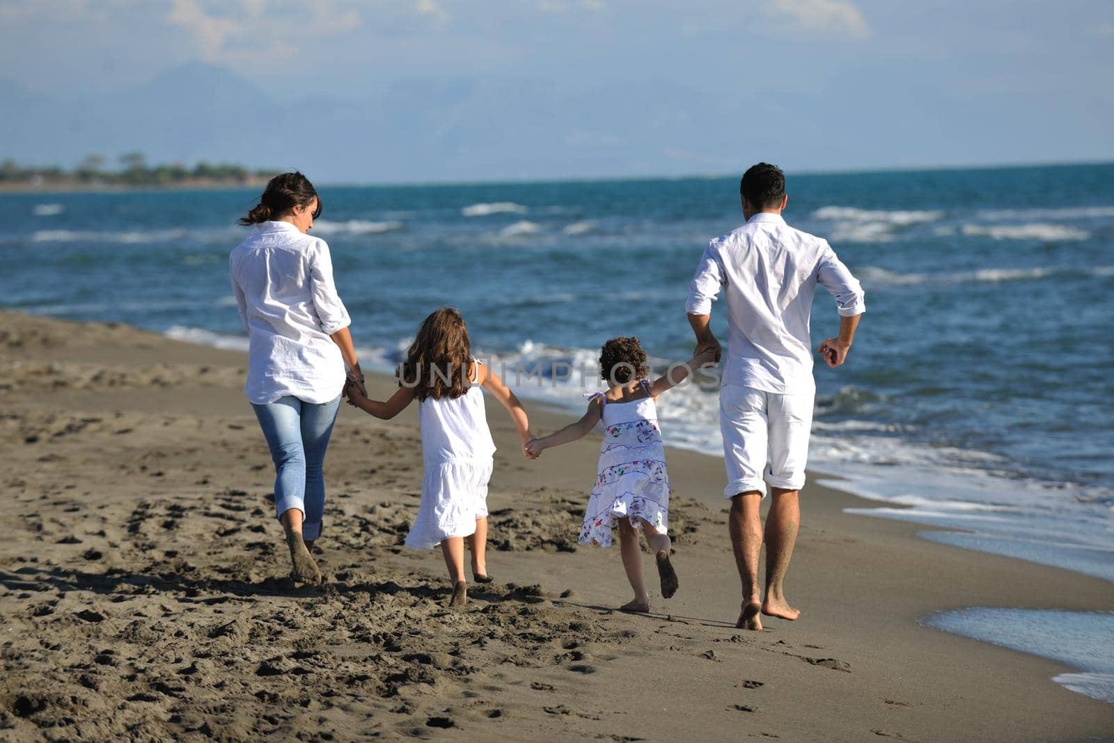 happy young family in white clothing have fun at vacations on beautiful beach 