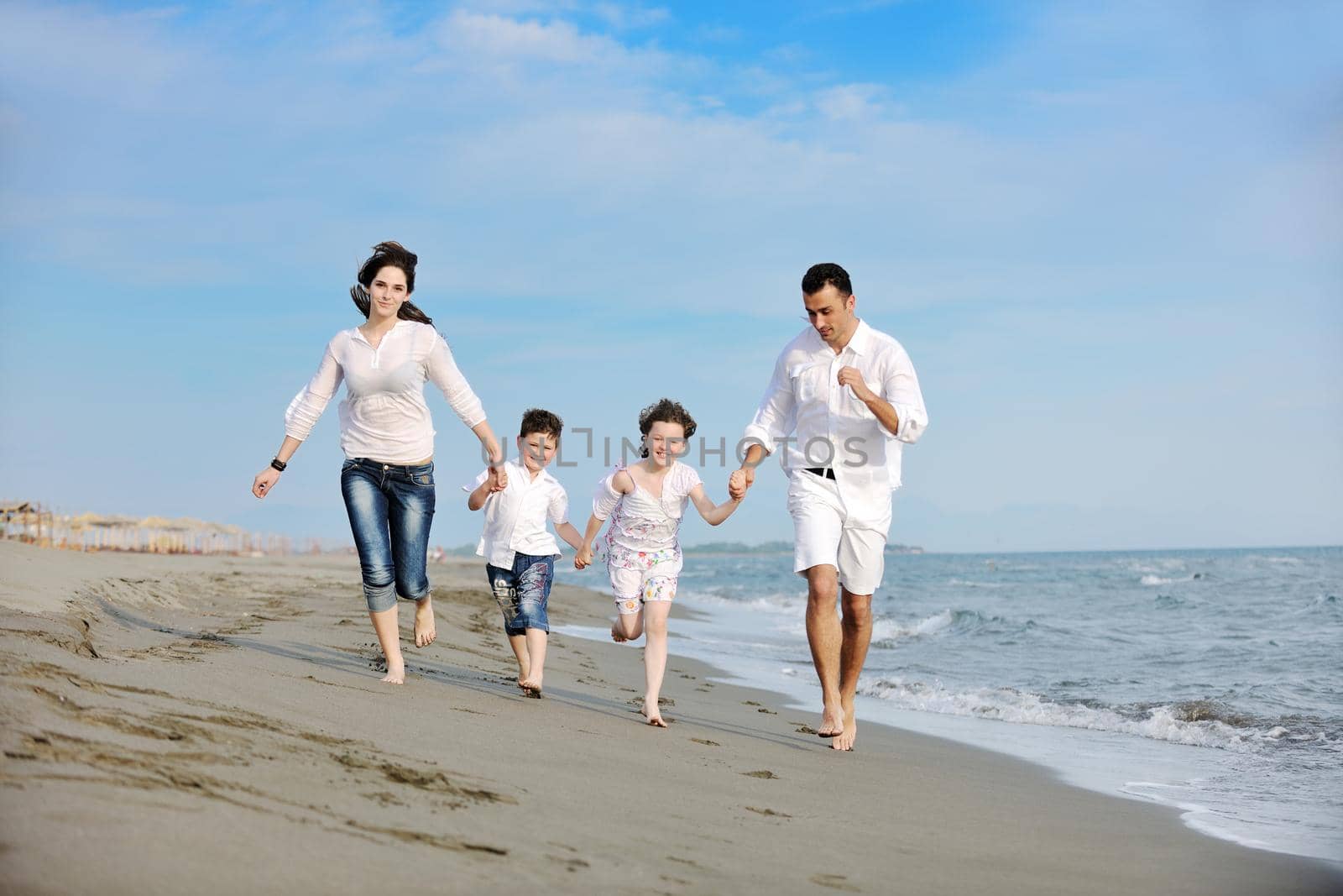 happy young family have fun and live healthy lifestyle on beach