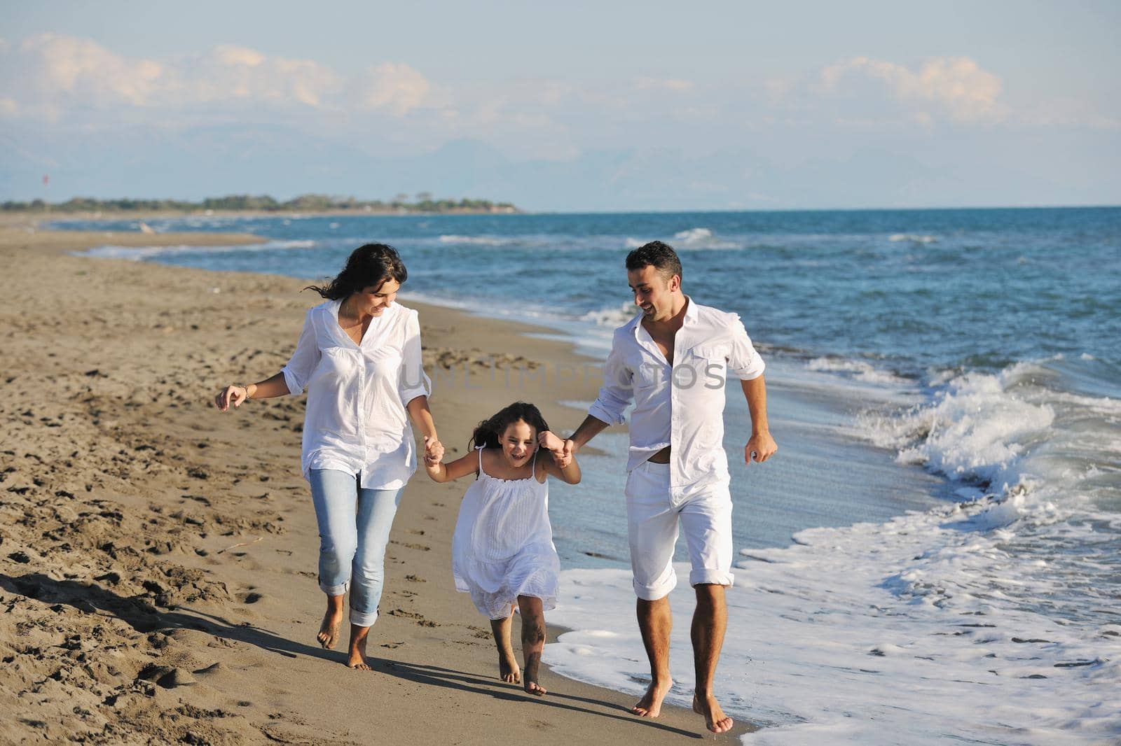 happy young family in white clothing have fun at vacations on beautiful beach 