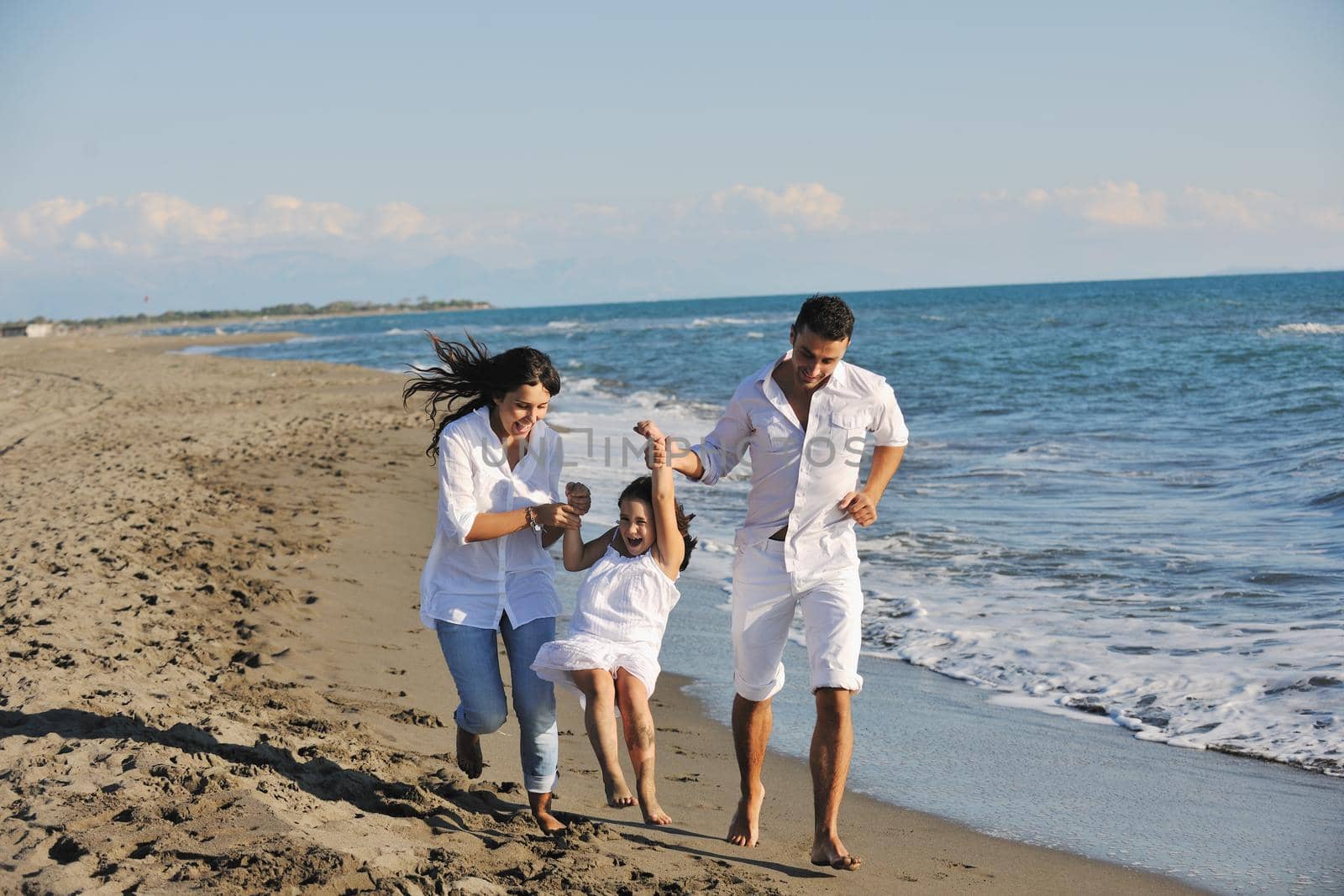 happy young  family have fun on beach by dotshock