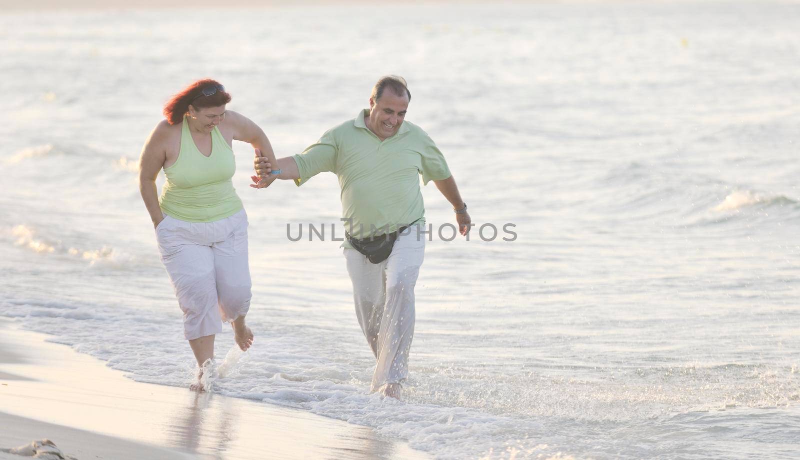 happy senior mature elderly people couple have romantic time on beach at sunset 