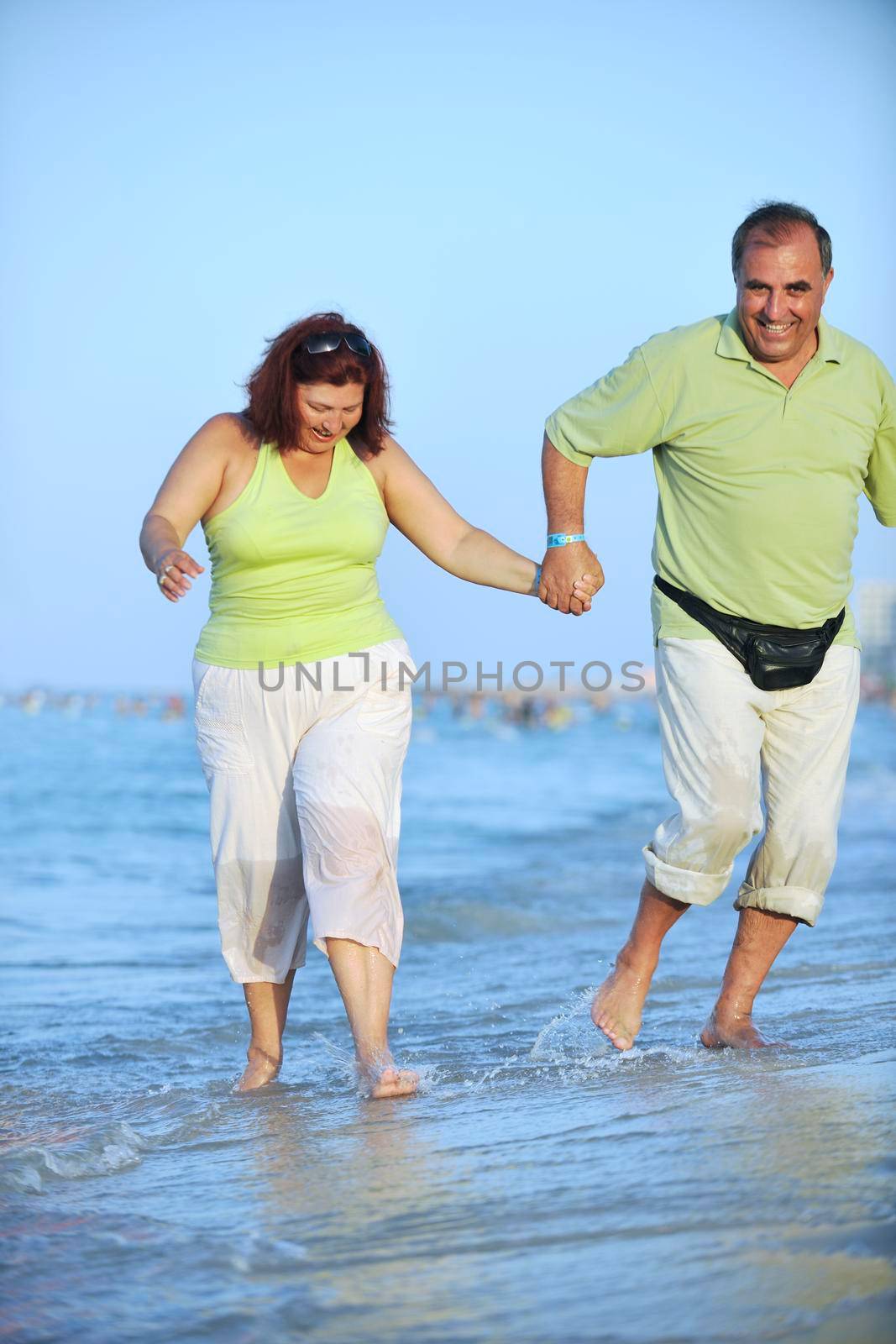 happy senior mature elderly people couple have romantic time on beach at sunset 