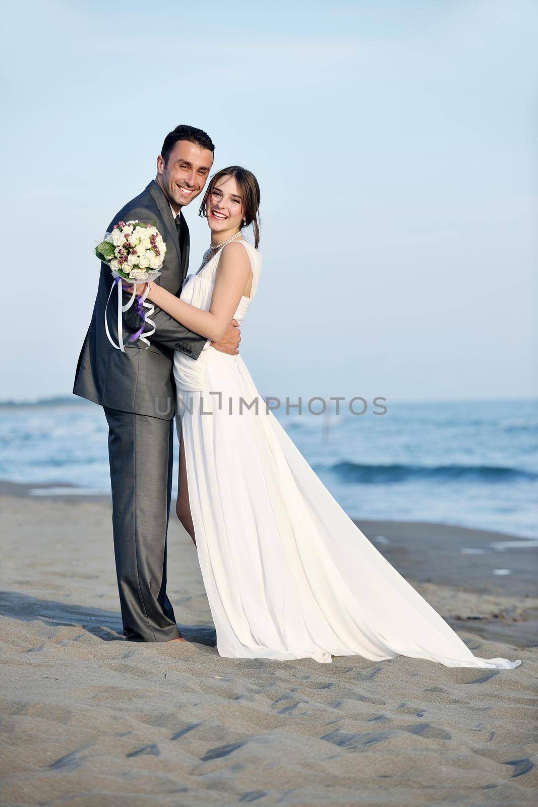 happy just married young couple celebrating and have fun at beautiful beach sunset