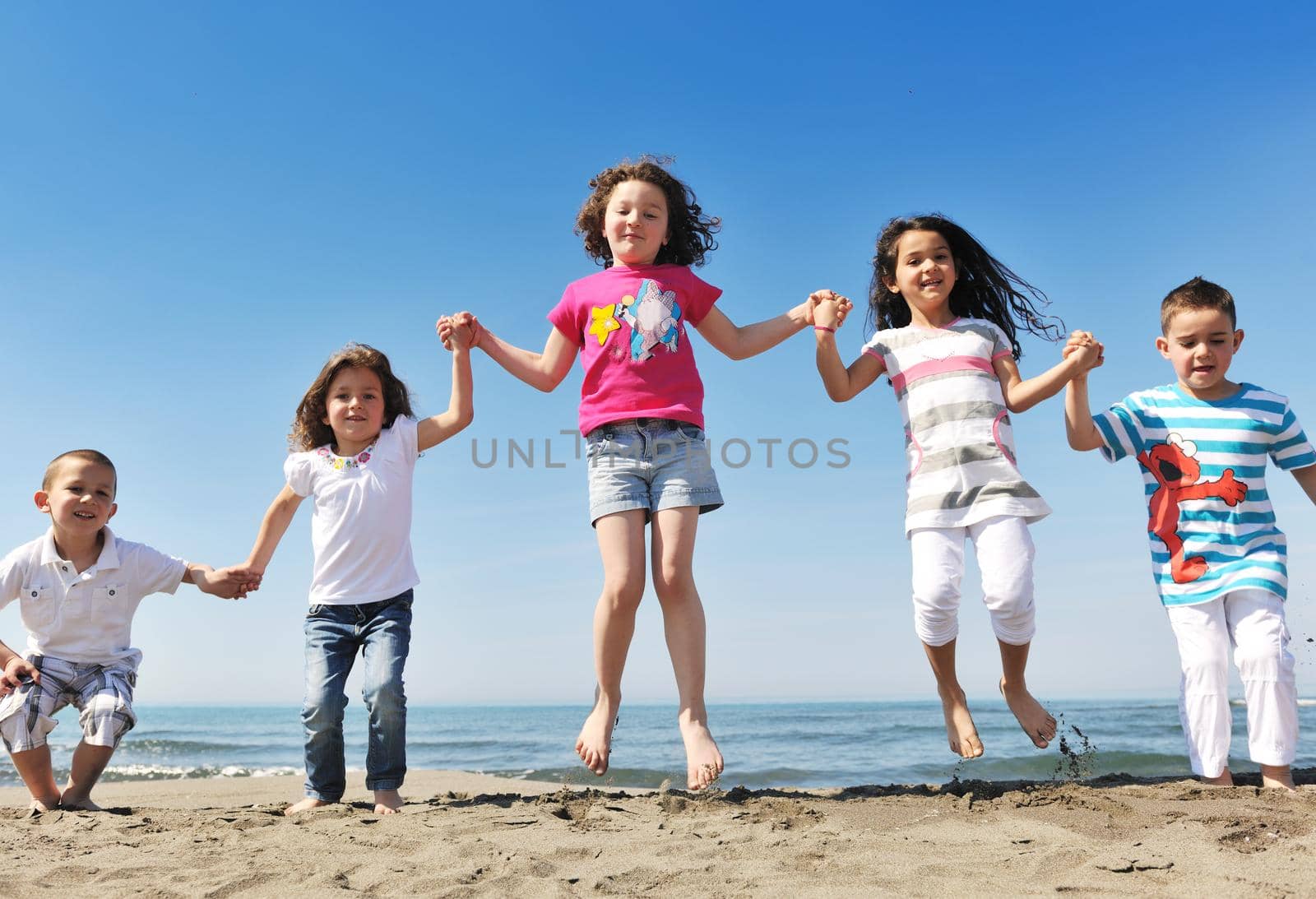 happy young people group have fun  run and jump  on beach beautiful sand  beach