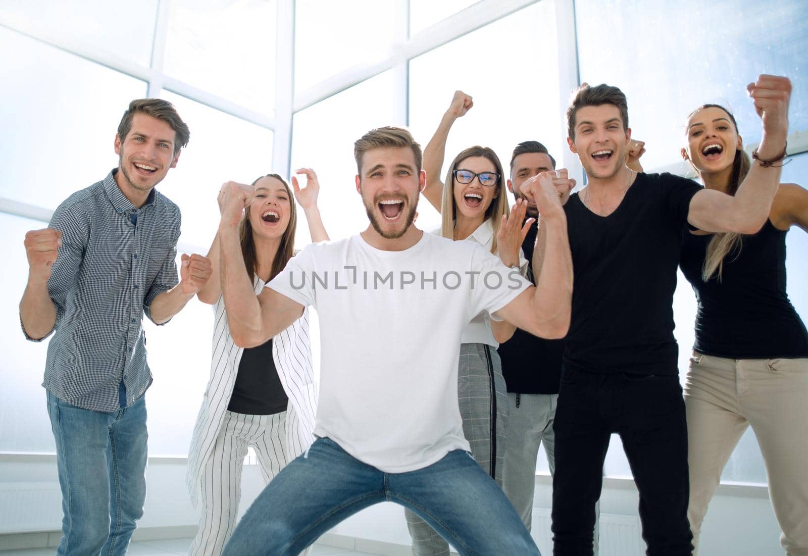 happy team of young employees standing in the office by asdf