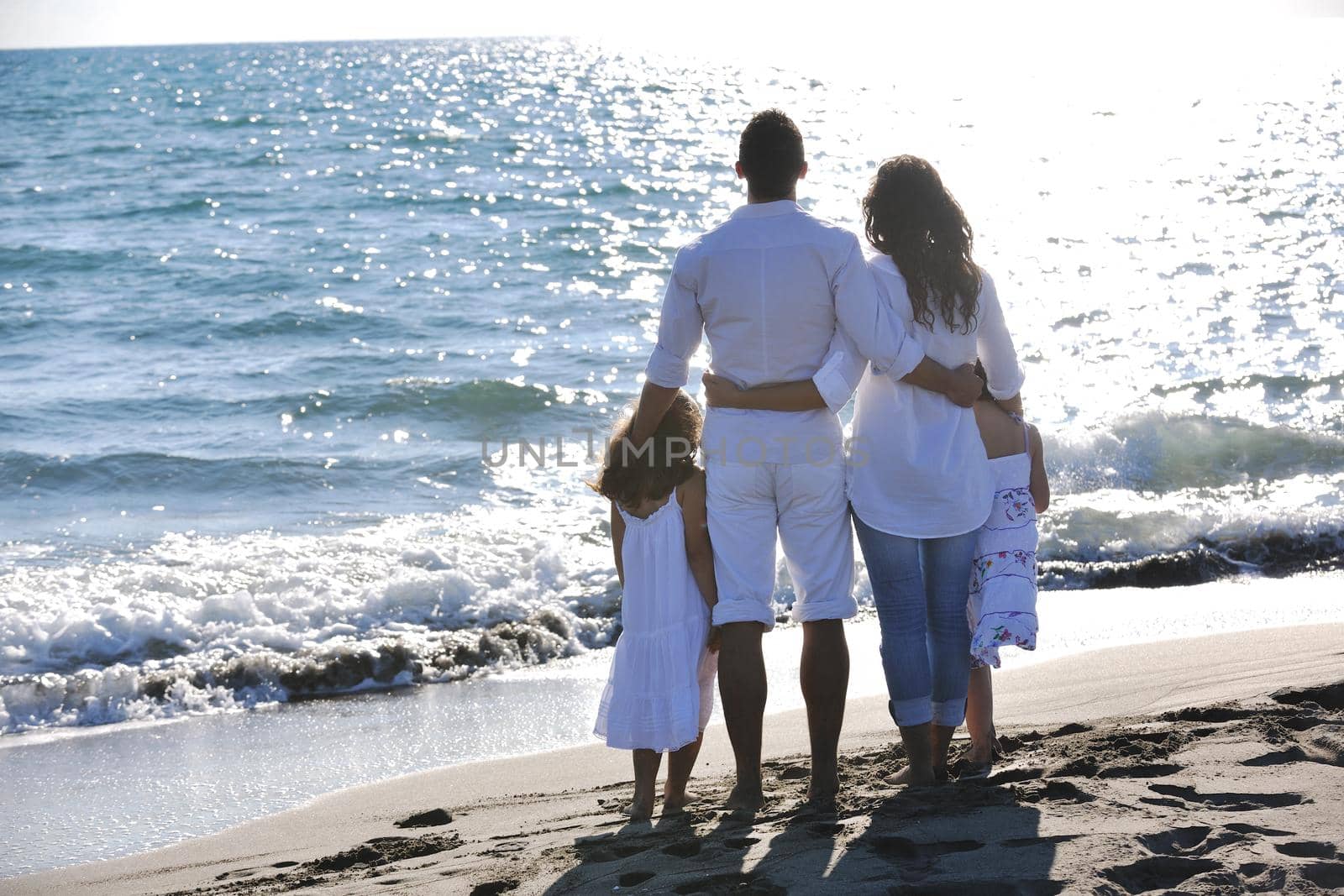 happy young family in white clothing have fun at vacations on beautiful beach 