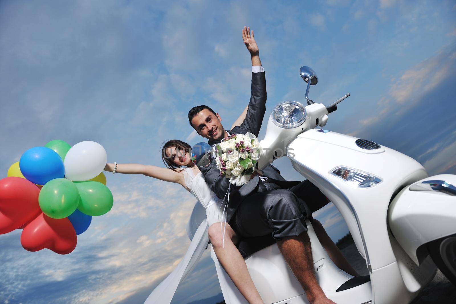 wedding sce of bride and groom just married couple on the beach ride white scooter and have fun