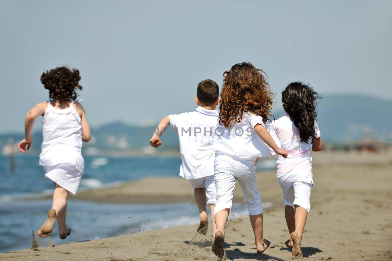 group of happy child on beach who have fun and play games