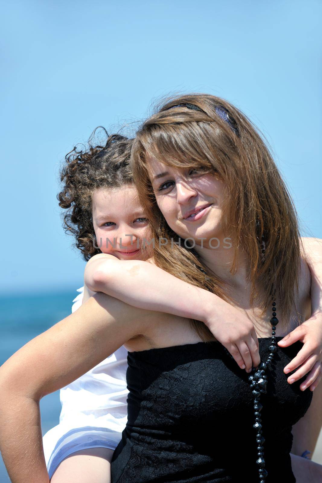 group portrait of happy childrens with young female  teacher on beach