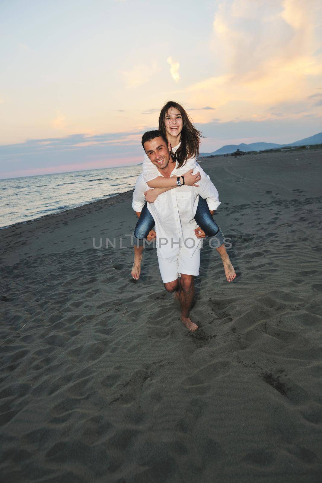 happy young couple have fun and romantic moments on beach at summer season and representing happynes and travel concept