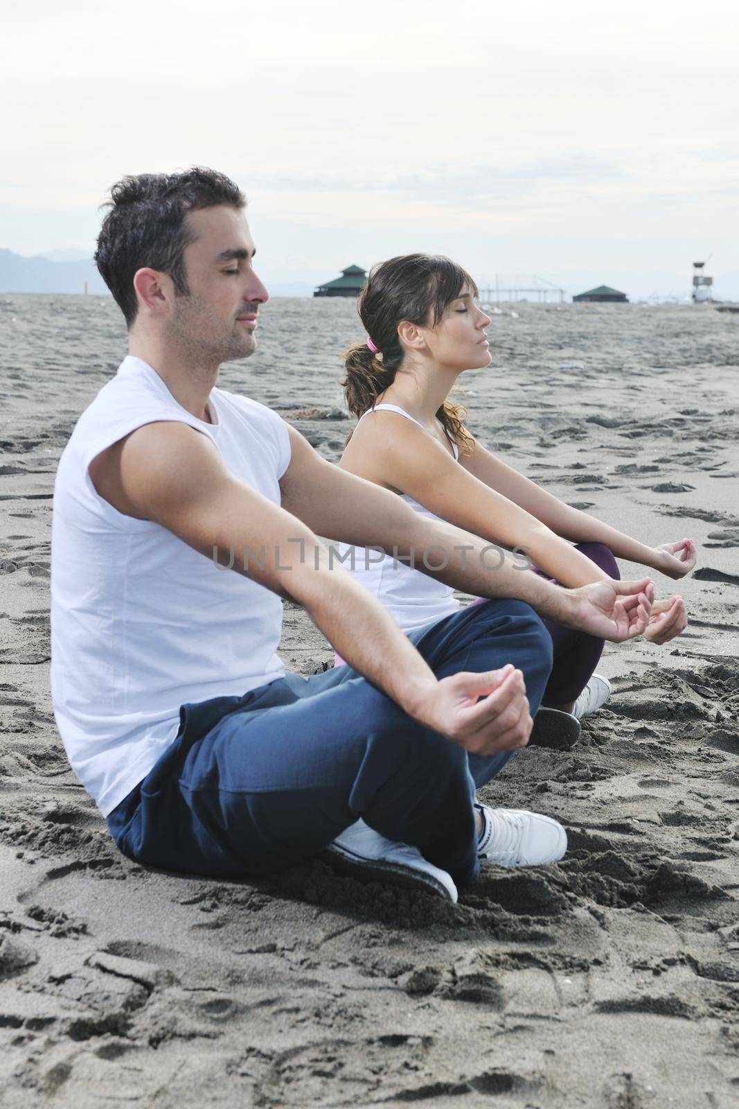 couple yoga beach by dotshock
