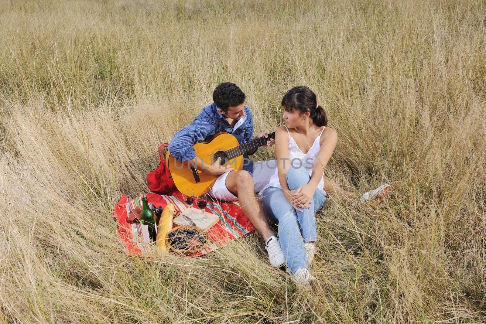 happy young couple enjoying  picnic on the countryside in the field  and have good time