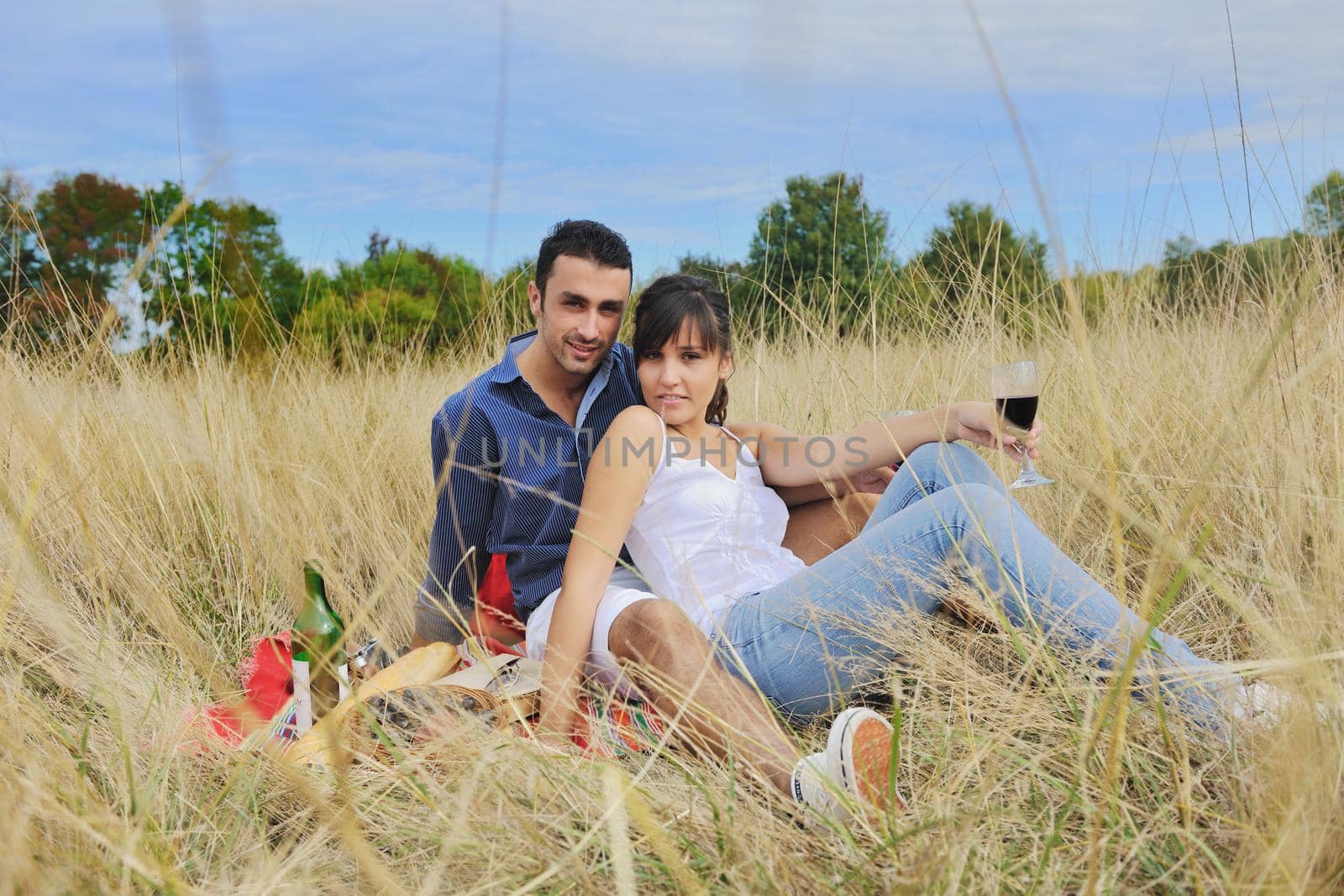 happy young couple enjoying  picnic on the countryside in the field  and have good time