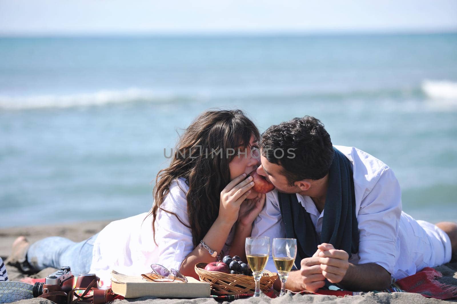 happy young couple enjoying  picnic on the beach and have good time on summer vacations