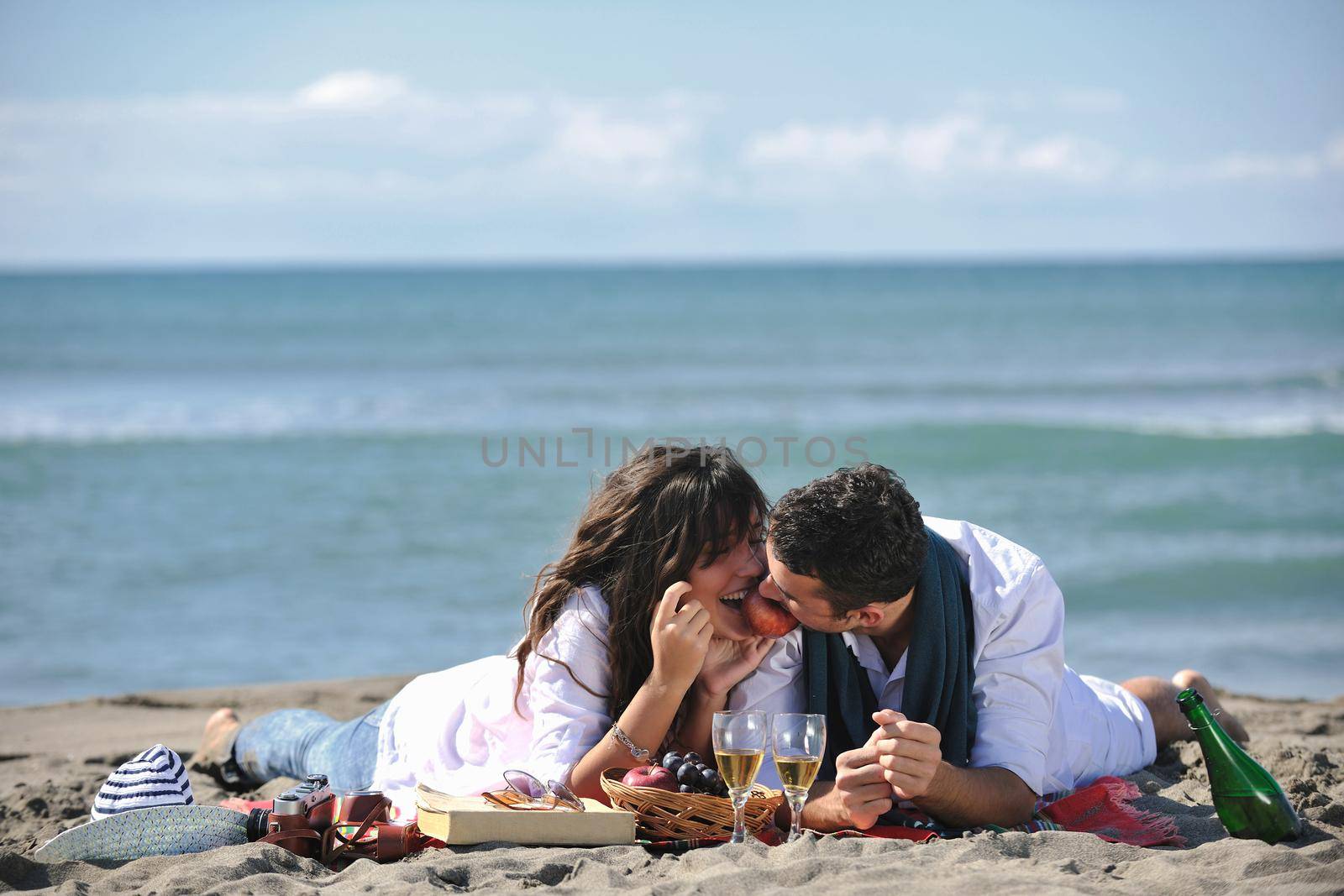 happy young couple enjoying  picnic on the beach and have good time on summer vacations