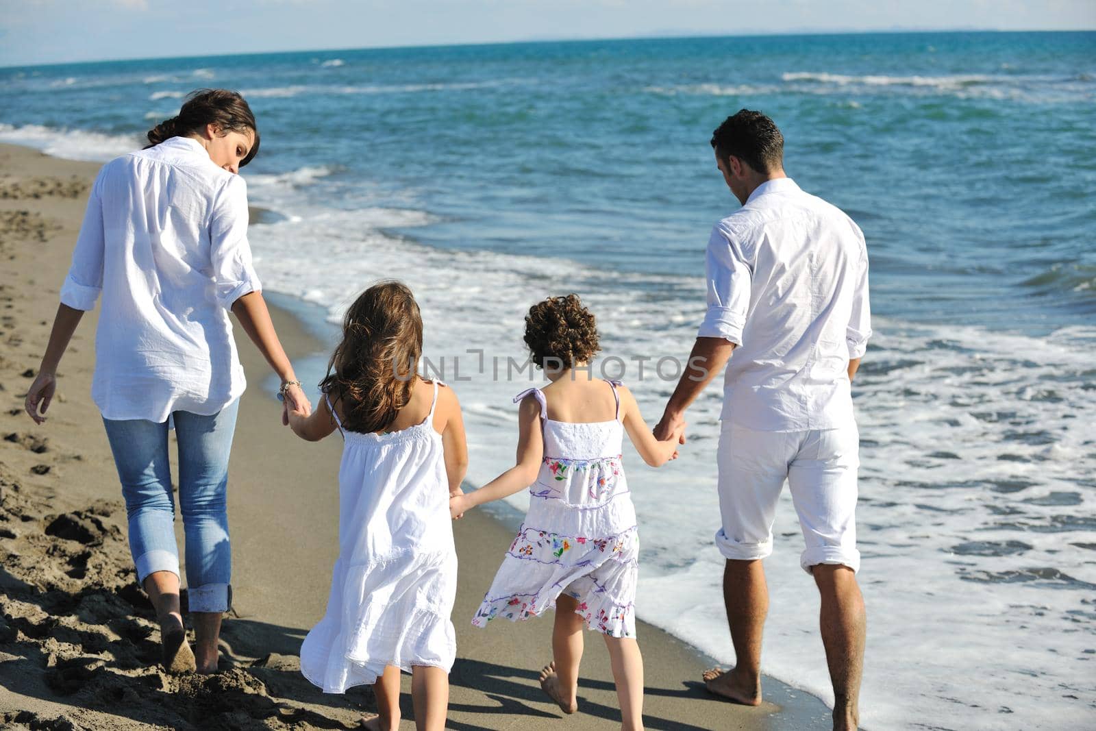 happy young family in white clothing have fun at vacations on beautiful beach 