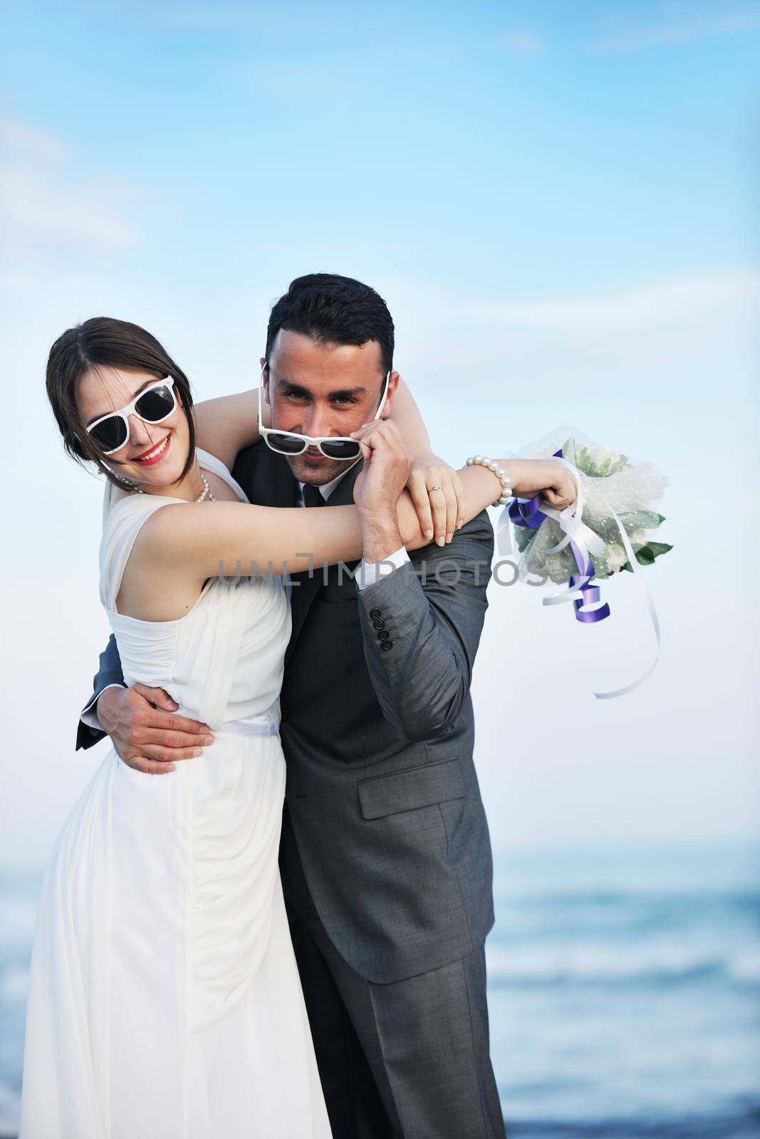 happy just married young couple celebrating and have fun at beautiful beach sunset