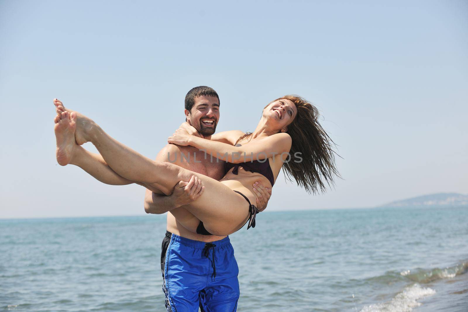 happy young couple have fun and romantic moments on beach at summer season and representing happynes and travel concept