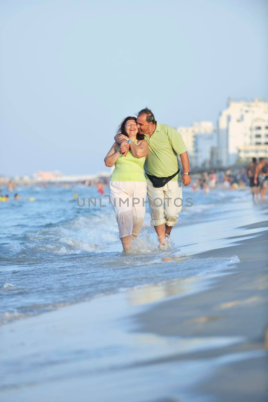 happy senior mature elderly people couple have romantic time on beach at sunset 