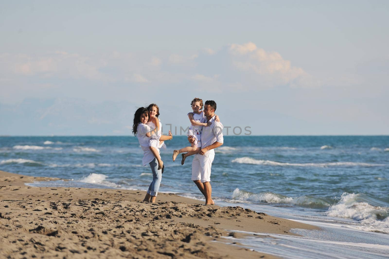 happy young family in white clothing have fun at vacations on beautiful beach 