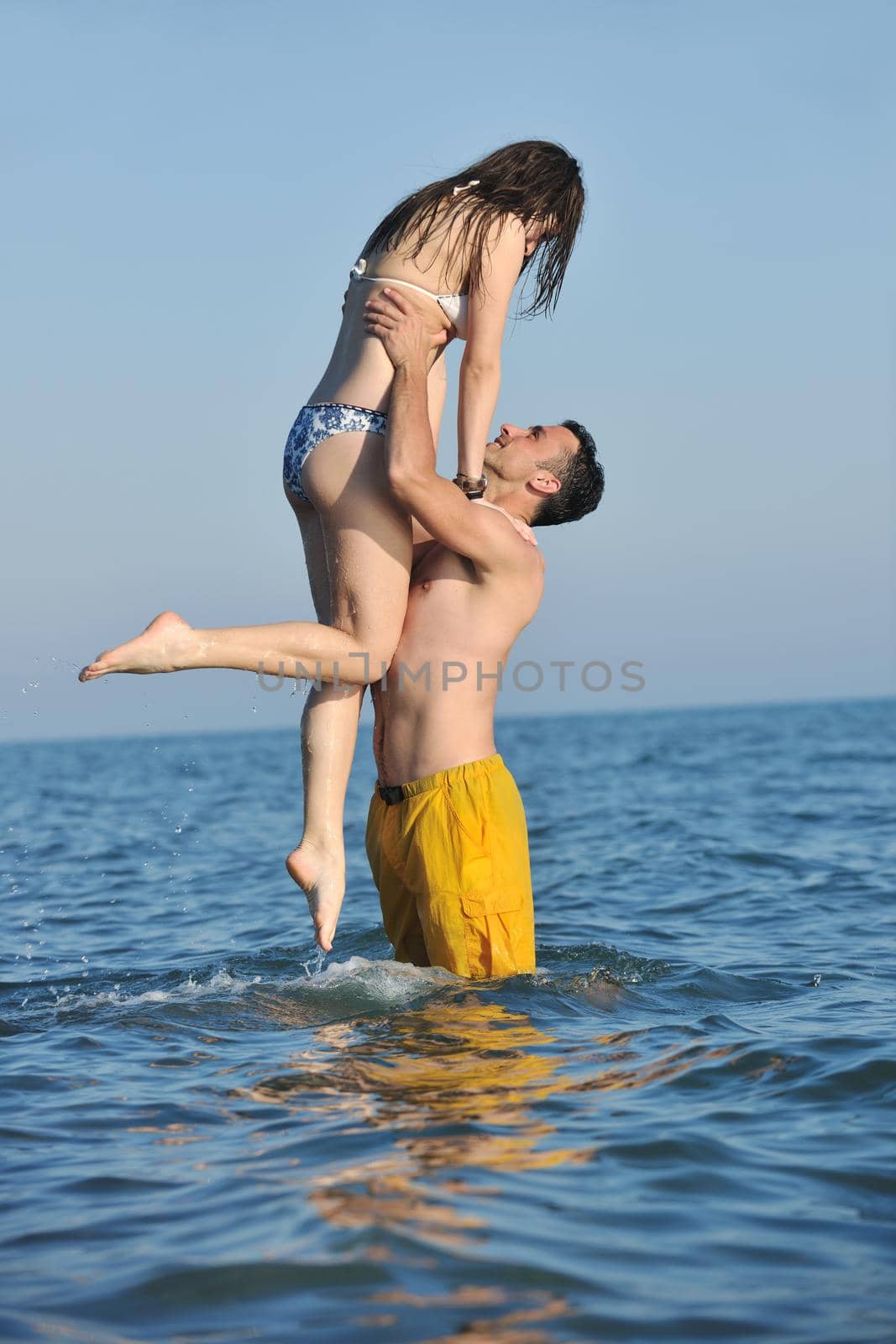 happy young couple have romantic time on beach by dotshock