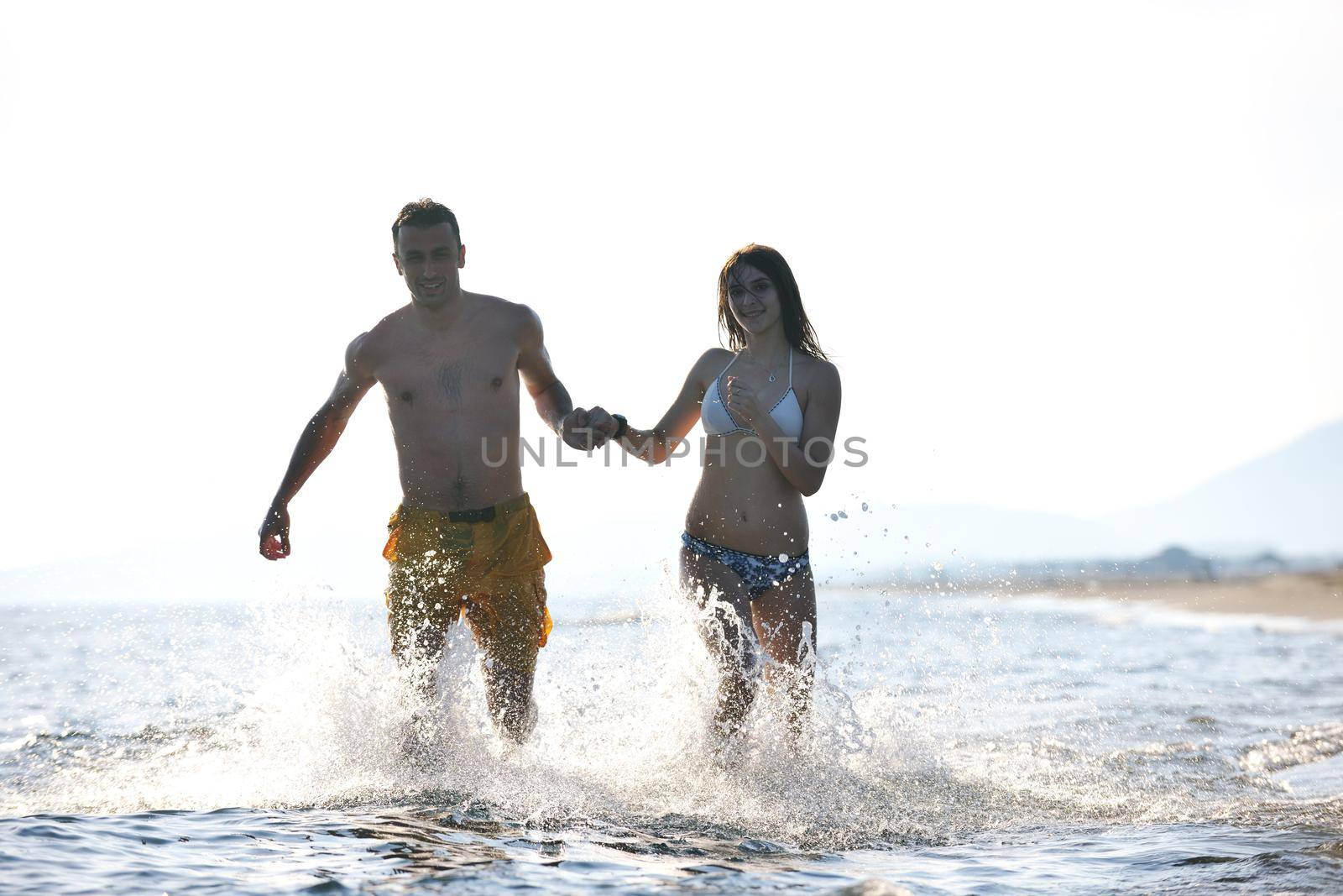 happy young couple have fun and romantic moments on beach at summer season and representing happynes and travel concept